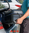 Bag Boy T-10 Travel Bag Cover in Black/Royal being placed into the trunck of a car.