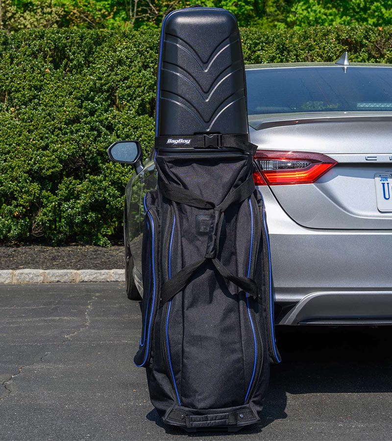 Bag Boy T-10 Travel Bag Cover in Black/Royal resting upright against a car