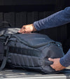 BAG BOY  ZTF Travel Bag Cover in black/charcoal being placed in a car trunk.