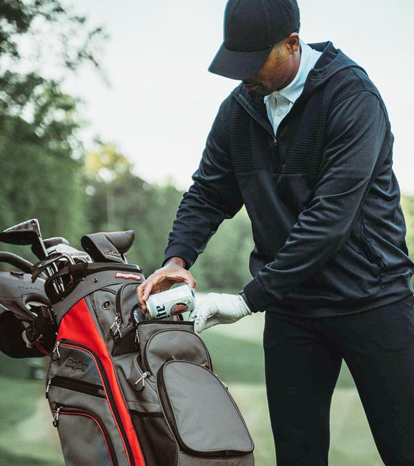 BagBoy Chiller Cart Golf Bag n Charcoal/Red/Black - male golfer getting a can from cooler pouch pocket