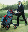BagBoy Quad Pro Golf Push Cart in Navy/Red - male golfer pushing cart with golf bag & clubs on the fairway