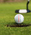 Callaway Chrome Soft Triple Track Golf Ball at lip of hole