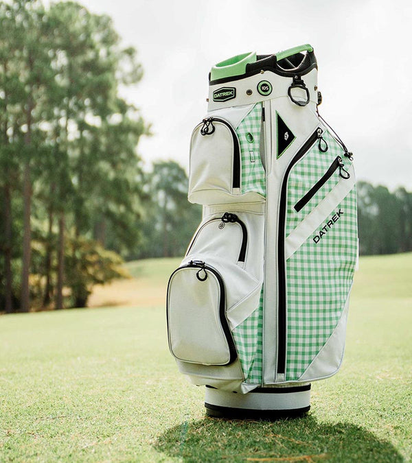 Datrek DG Lite III Golf Cart Bag in White/Green/Checkered upright on the fairway.