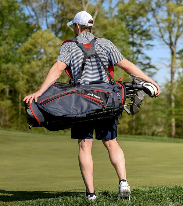 Golfer carrying on back the Datrek Go Lite Hybrid Golf Stand Bag in Charcoal/Black/Red