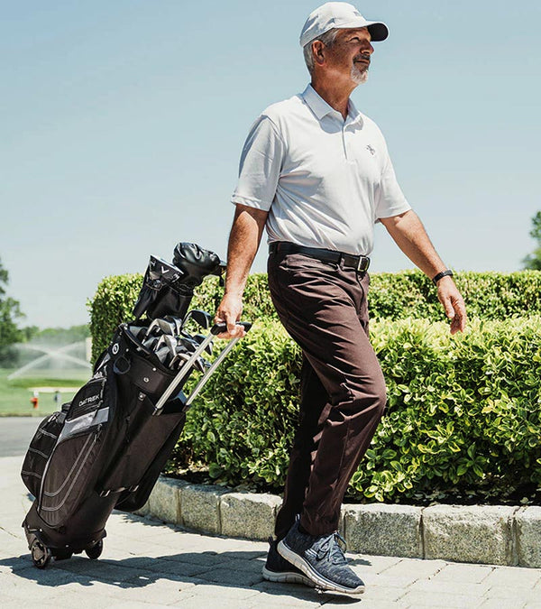 Datrek Transit Cart Golf Bag in Black/Charcoal/Silver being pulled by older male golfer along sidewalk