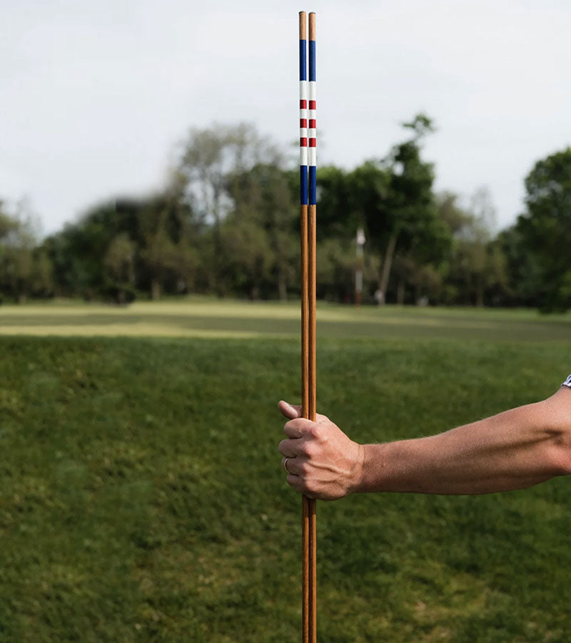 HazyGolf Alignment Sticks – American Glory - pair vertical held by a go;fer on a fairway