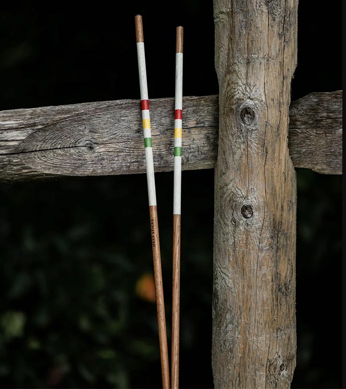 HazyGolf Alignment Sticks – The Icon - pair vertical leaning against a wooden fence