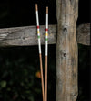 HazyGolf Alignment Sticks – The Icon - pair vertical leaning against a wooden fence