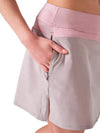 Inphorm MAI 17" Wrap Golf Skirt in Dusty Pink/Latte - partial model - closeup side view with hand in pocket