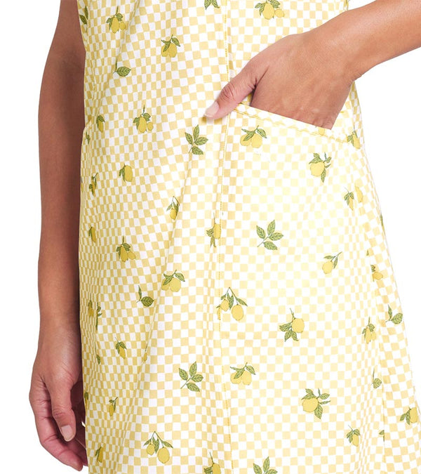 Puma Lemons Woven Womens Golf Dress- closeup with hand in front pocket in Sunny Yellow, an allover lemon print on a cheerful yellow-and-white checkered background.