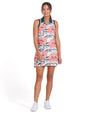Puma MATTR Beautiful Game Womans Golf Dress- model in a tropical White Glow / Peach Frost print with green collar and green banded armholes - front view