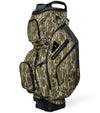Sunday Golf The Big Rig Golf Cart Bag in Mossy Oak Bottomland Camo with black accents on details like zippers, base and top club divider showing a three quarter front/side view