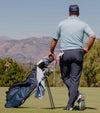 Sunday Golf Ryder Full Size Stand Golf Bag in Navy Blue – Male golfer standing with back to viewer on a golf course.