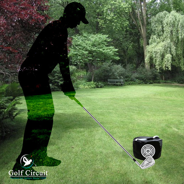 Silhouette of male golfer in backyard practicing hitting an impact smash bag