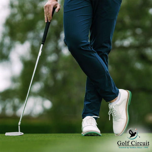 Legs and hand of casual golfer poised with TaylorMade putter 