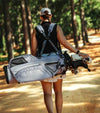Datrek Go Lite Hybrid Golf Stand Bag legs extended with top divider view next to bag in Lavender/White/Gray female golfer carrying with double strap