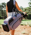Datrek Go Lite Hybrid Golf Stand Bag legs extended with top divider view next to bag in Lavender/White/Gray female golfer carrying  on  shoulder