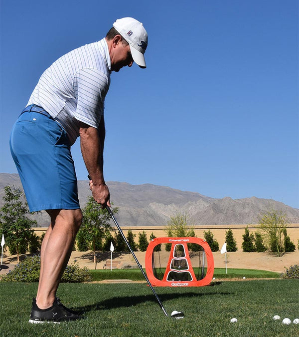 Gosports Chipster Golf Chipping Training Net - in the foreground is a male golfer outside practicing with wedge and golf balls