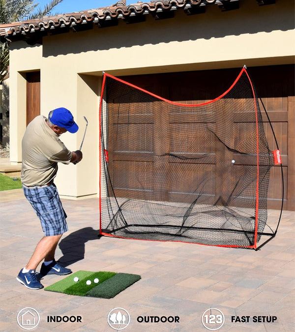 GoSports Golf Practice Hitting Net 7 Ft X 7 Ft - Golfer practicing in driveway with wood garage door behind the net