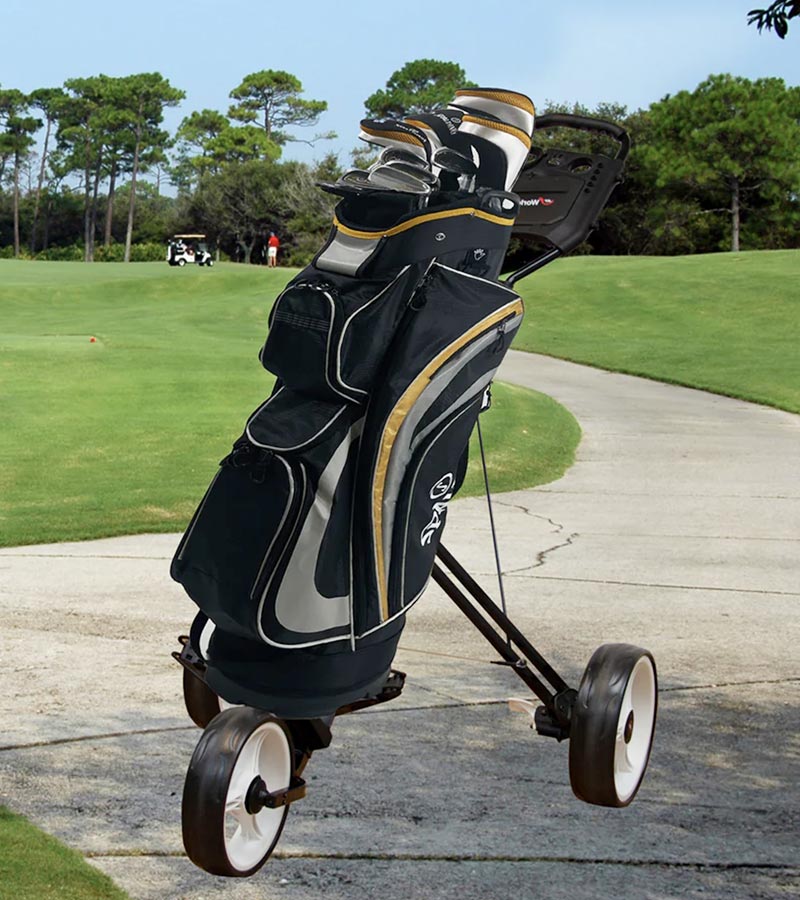 JEF World of Golf Navigator 3-Wheeled Push Cart - on sidewalk of a golf course holding a golf bag