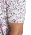 Puma Mens AP Floral Golf Polo Shirt closeup of the short sleeve in White Glow / Pale Pink with a vibrant all over abstract floral. The collar is the solid coordinating color with a lighter contrast color for the inner collar and the 3 button inner placket.