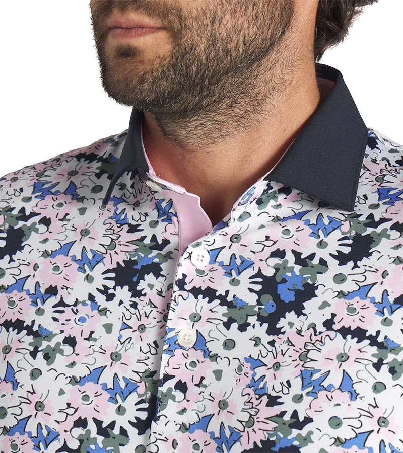 Puma Mens AP Floral Golf Polo Shirt closeup of collar in White Glow / Deep Navy with a vibrant all-over abstract floral. The collar is a solid coordinating color with a lighter contrast color for the inner collar and the 3 button inner placket.
