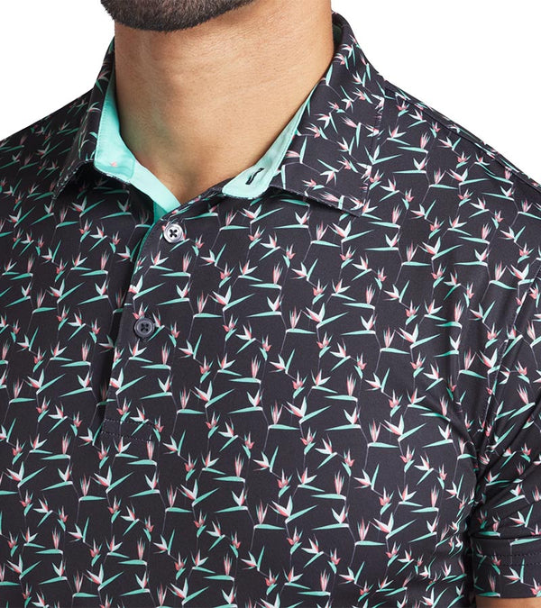 Puma Mens MATTR Paradise Golf Polo closeup of collar in Puma Black / Aquatic  with a with an  all-over pattern floral of little birds of paradise flowers with contrast color accent  inside collar and button placket.