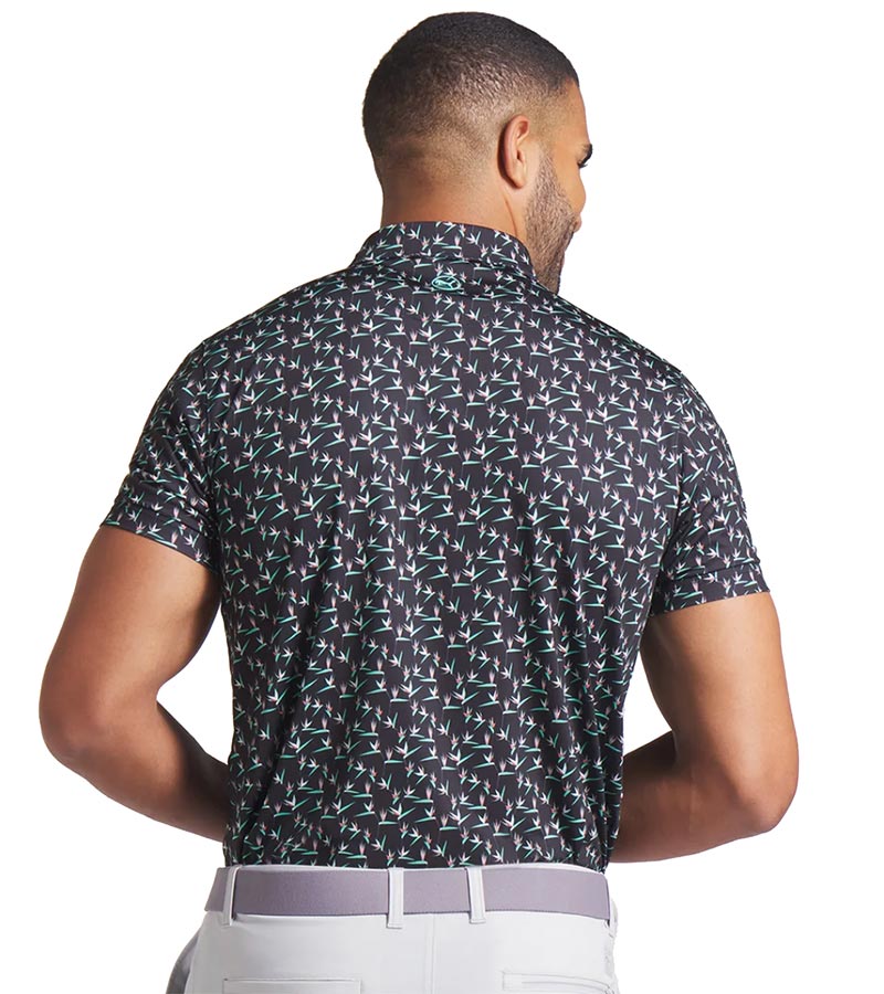 Puma Mens MATTR Paradise Golf Polo Model back in Puma Black / Aquatic  with an  all-over pattern floral of little birds of paradise flowers with contrast color accent  inside collar and button placket.