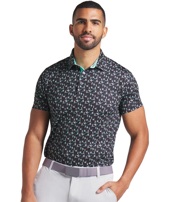 Puma Mens MATTR Paradise Golf Polo Model Front in Puma Black / Aquatic  with an  all-over pattern floral of little birds of paradise flowers with contrast color accent  inside collar and button placket.