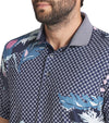 Puma Mens MATTR Terrance Golf Polo Shirt closeup of collar in Deep Navy with a widely spaced group of tropical flowers & leaves on a small set geometric navy background.