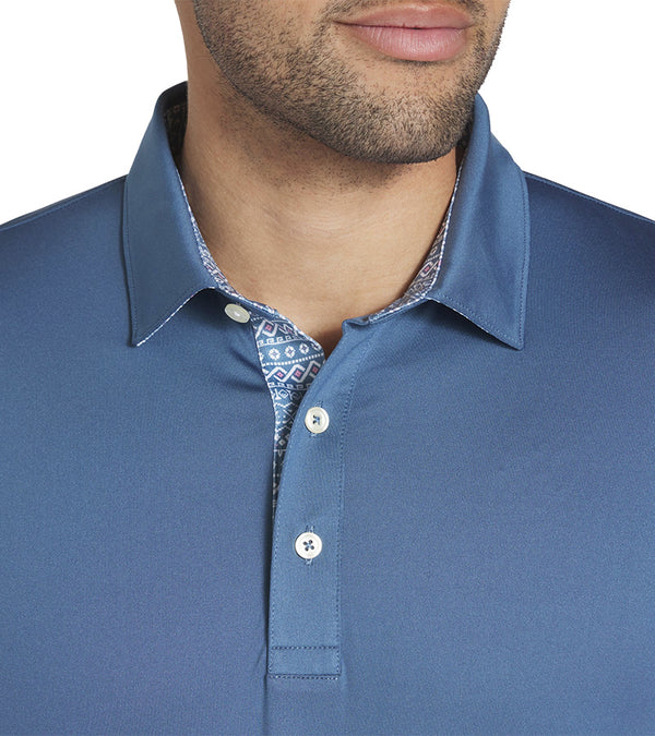 Puma Mens Fair Isle Trim Golf Polo Shirt closeup of the collar in solid Blue Horizon with the geometric print from the Fair Isle Micro golf polo lining the entire inner and under section of the collar and 3 button placket for a distinctive accent to the shirt.