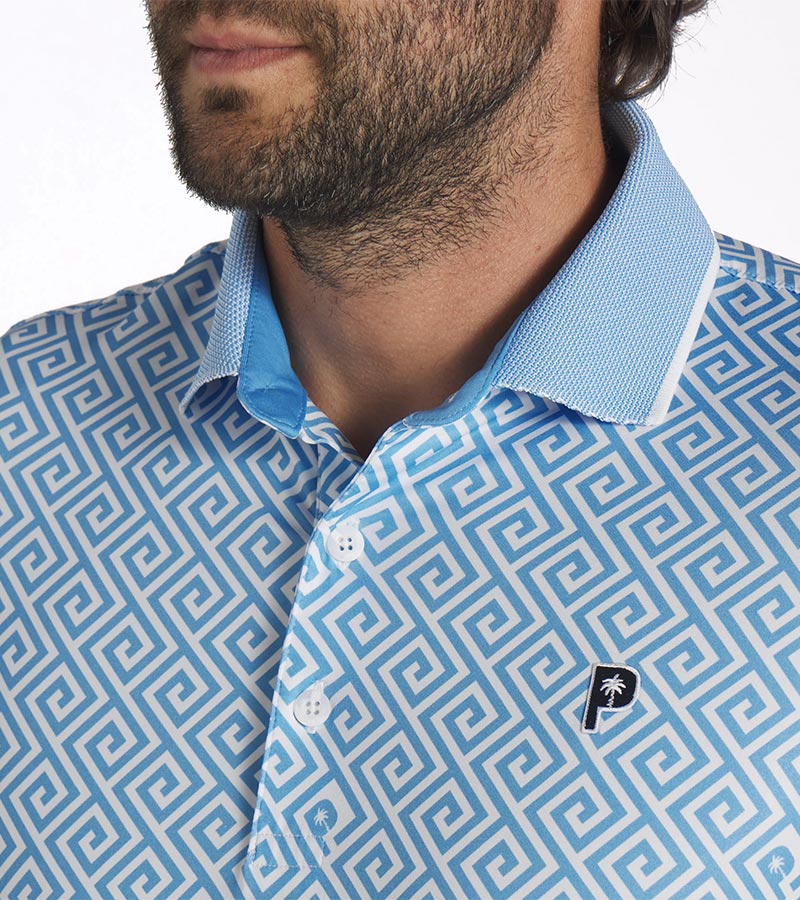 Puma Mens x PTC Resort Golf Polo Shirt closeup of collar in Regal Blue / White Glow
 has an all-over Greek key design, white piping along the collar’s edge with Regal Blue accent color on the inner collar and a 3 button placket. 