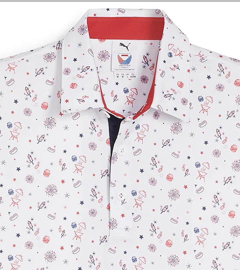 Puma Mens Volition Celebration Golf Polo Shirt closeup of collar in White Glow / Deep Navy has a fun print showcasing fireworks and BBQ motifs, embodying the spirit of summer festivities and patriotic pride. The red inside of the collar and the navy blue of the 3 button inner placket add a pop of accent colors to finish this patriotic red, white and blue color scheme.