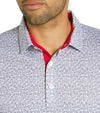 Puma Mens Volition Football Golf Polo Shirt closeup of collar in Deep Navy / White Glow with an all over small tossed footballs. The red accent color of the inner collar and 3 button placket gives a pop to the all over look.