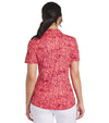 Puma Womens CLOUDSPUN Zebra Golf Polo Shirt model back in Salmon / Intense Red featuring a bold all over zebra pattern with a coordinating solid accent color for the inner collar and inner button placket.