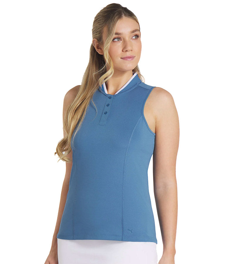 PUMA Women's Range Pique Sleeveless Golf Polo shirt model front in solid Blue Horizon with model front featuring a ribbed collar with white contrast piping and a three-button placket.