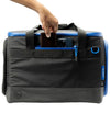 Sunday Golf Creator Duffle Bag with blue accents. A hand holds a wallet being placed in an outside pocket along with a mobile phone 