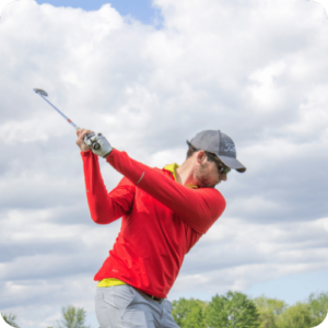 golfer in red shirt swinging club