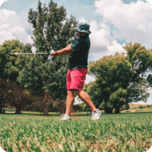 golfer in pink shorts hitting low golf shot