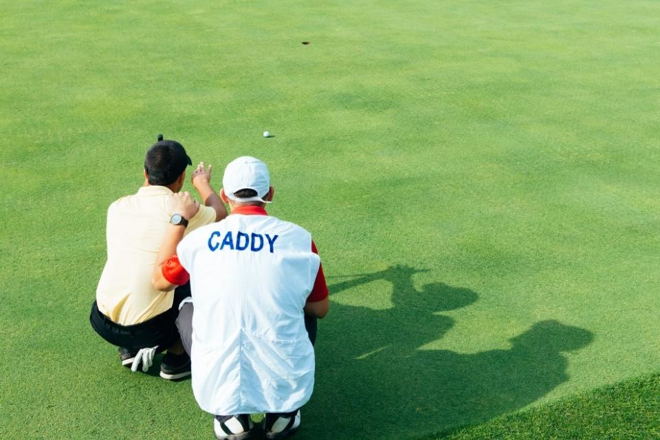 golf caddie sitting with golfer