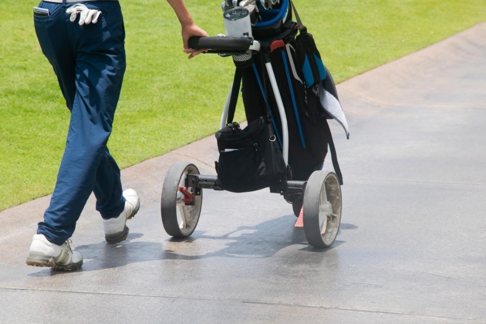 golf caddie walking with cart
