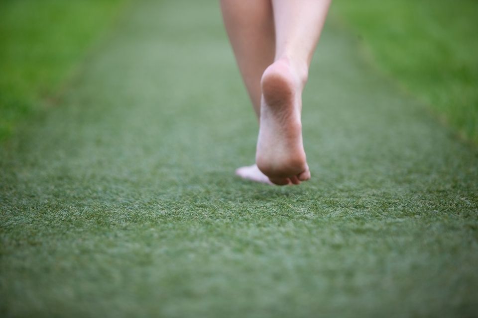 Golfer walking on the grass barefoot