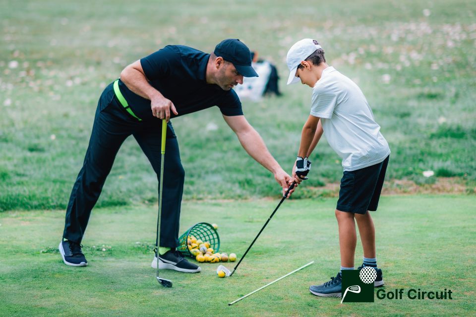 Adult helping kid stop topping the golf ball